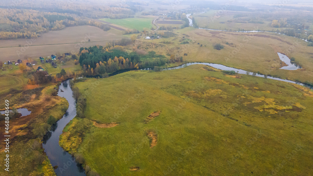 Top view autumn landscape with yellow trees on bank of small river. Nature concept. Top view autumn landscape with yellow trees on bank of small river. Nature concept.