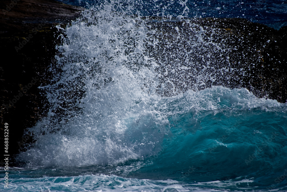 Large wave crashing on rocks in Hawaii