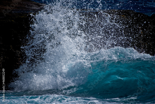Large wave crashing on rocks in Hawaii