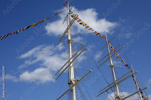Waving nautical signal flags on the masts of an old sailing vessel under a blue late summer sky, Hamburg, Germany
