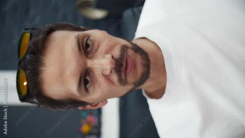 Caucasian man blogger on the street against the background of a brick building looks into the camera and says Caucasian man blogger on the street against the background of a brick building looks into the camera and says