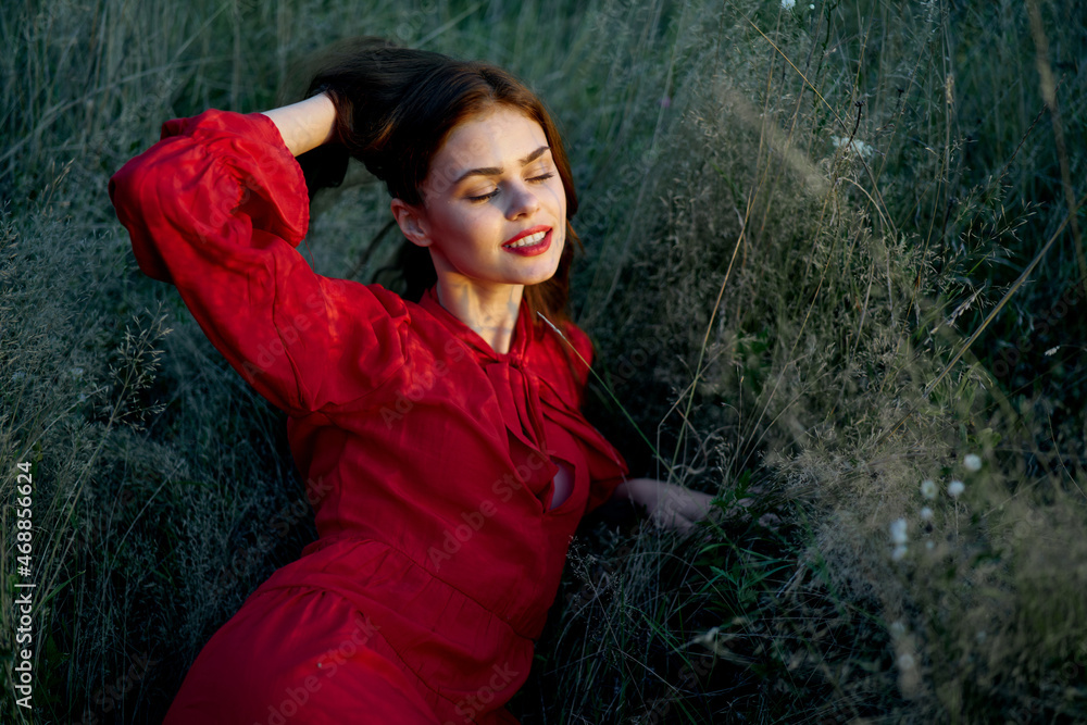 pretty woman in red dress lies on the grass nature sun pretty woman in red dress lies on the grass nature sun