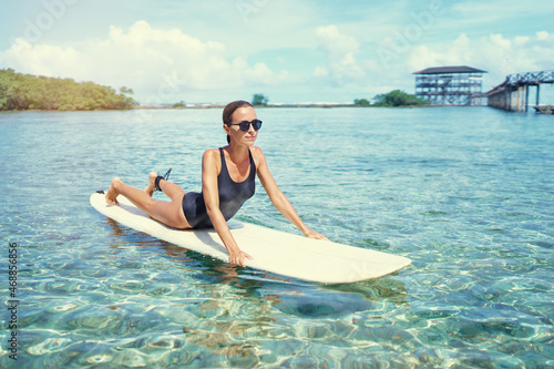 Hobby and vacation. Sunny holiday on the beach. Young surfer woman surfing having fun on Cloud Nine Spot, Siargao Beach, Philippines.