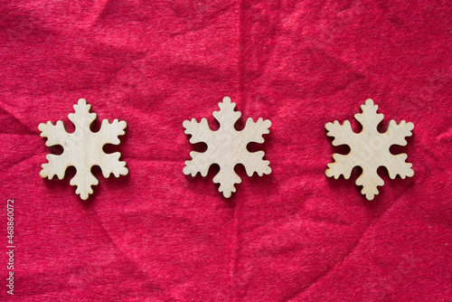 christmas themed background with snowflake ornaments made of wood on felt © eugen
