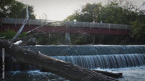 Pont rouge au dessus d'une riviere avec barage
