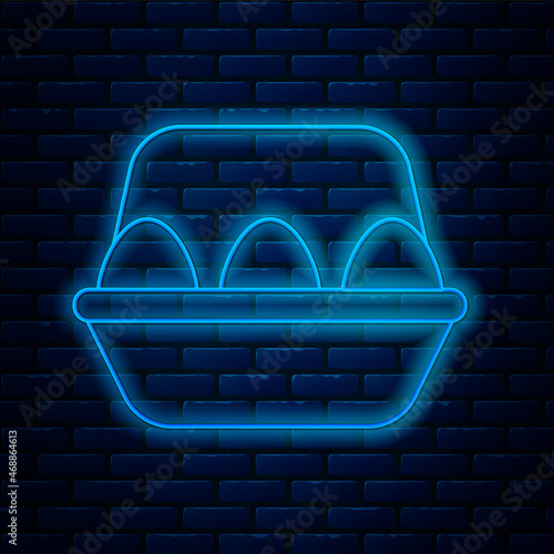 Glowing neon line Chicken egg in box icon isolated on brick wall background. Vector