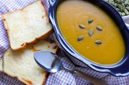 Autumn pumpkin cream soup on the table. Seasonal autumn food. photo