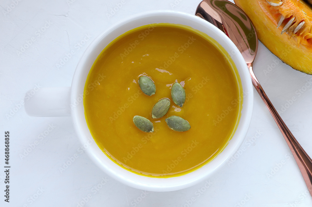 Autumn pumpkin cream soup and pumpkins on white background. Seasonal autumn food. Autumn pumpkin cream soup and pumpkins on white background. Seasonal autumn food.