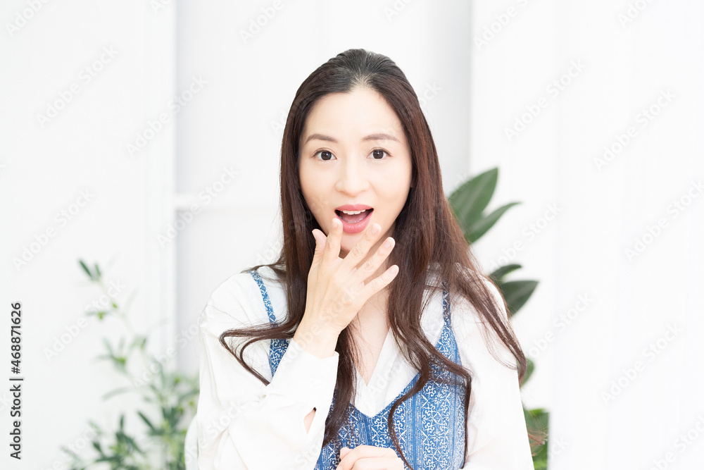リビングで驚いたポーズをする主婦 リビングで驚いたポーズをする主婦