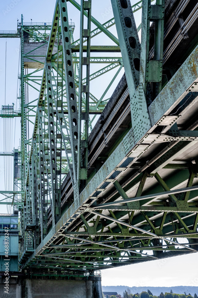 Riveted frame of a powerful sectional arched lifting transport bridge on concrete supports over the Columbia River in the West of America