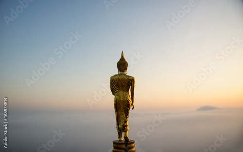 Big golden buddha statue standing in Wat Phra That Kao Noi on morning at Nan province Thailand