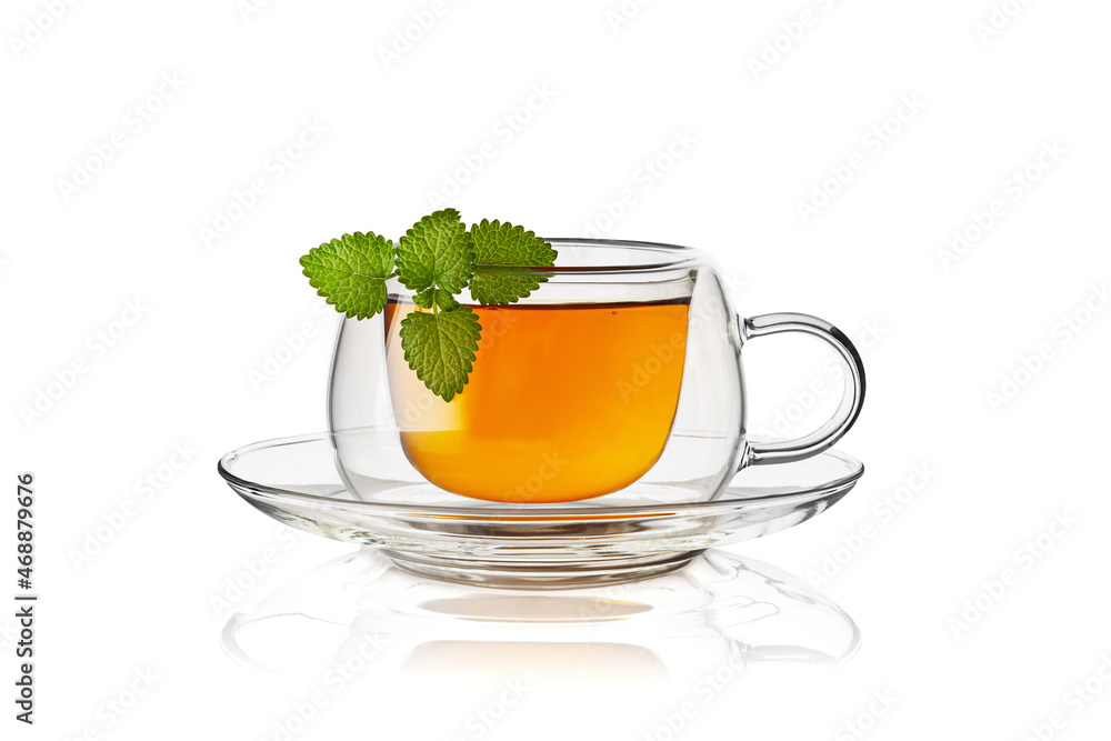 Transparent double glass cup with tea and mint leaves on white background. Horizontal. Studio shot. Transparent double glass cup with tea and mint leaves on white background. Horizontal. Studio shot.