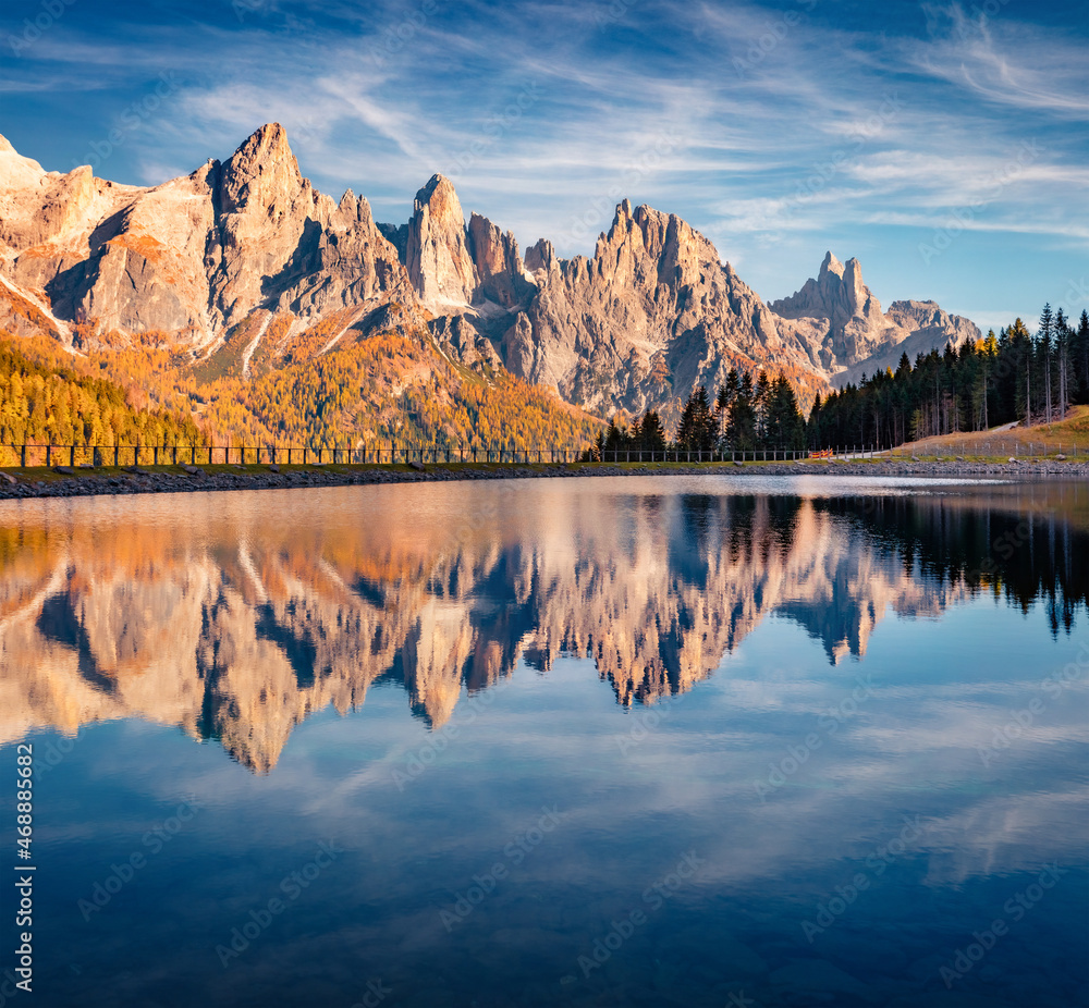 Fototapeta premium Pala di San Martino Mountain Range reflected in the surface of Malga Ces Lake. Superb autumn view of Dolomite Alps. Gorgeous outdoor scene of Italy, Europe. Beauty of nature concept background..