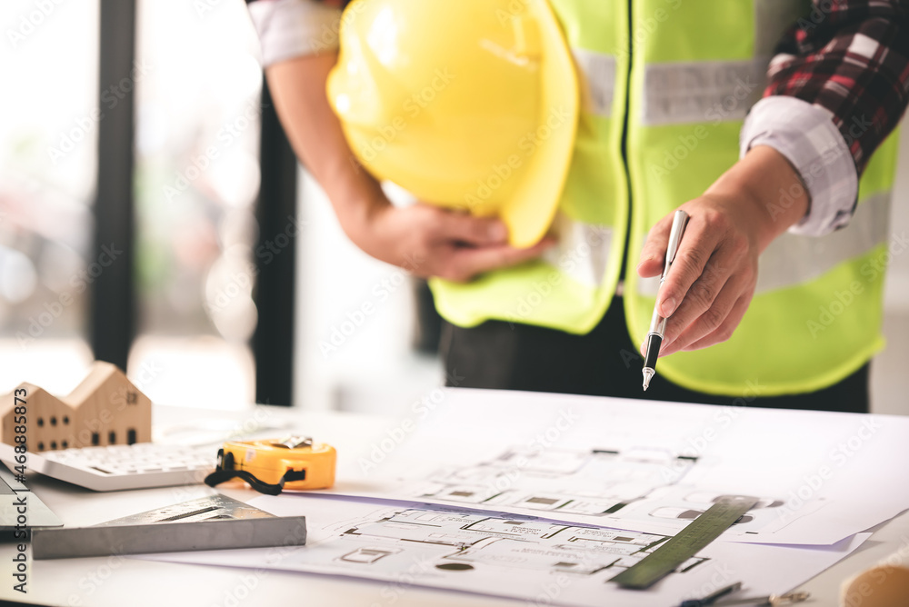 architect concept, working architect with blueprints in office to present to customers architect concept, working architect with blueprints in office to present to customers
