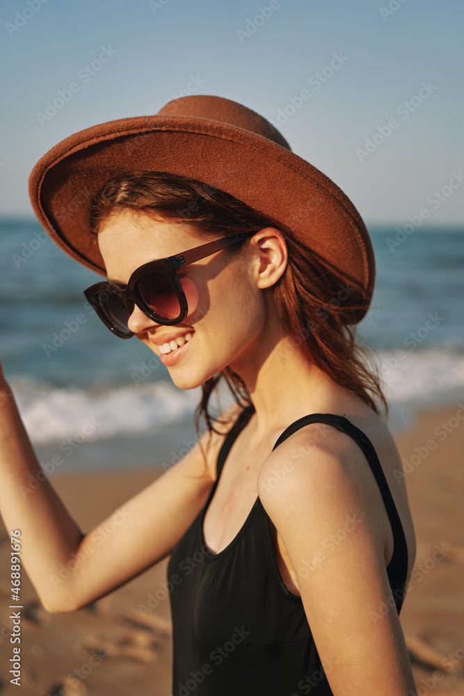 pretty woman in hat and sunglasses on the beach walk sun