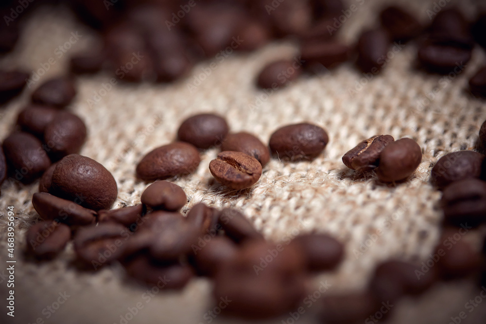 Close-up of roasted coffee beans spread over the bag. Coffee, beans Close-up of roasted coffee beans spread over the bag. Coffee, beans