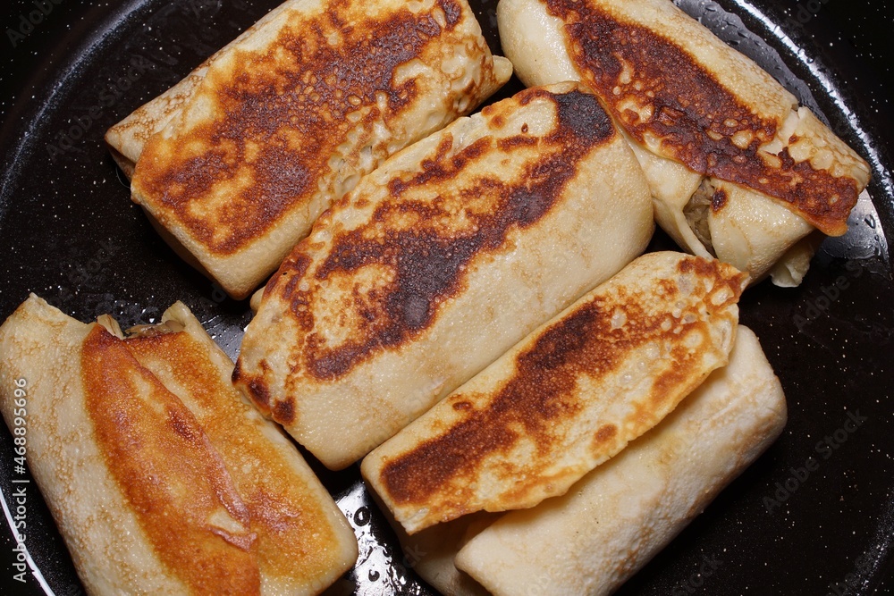 pancakes stuffed with cabbage and mushrooms, frying in a pan pancakes stuffed with cabbage and mushrooms, frying in a pan