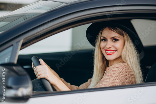 Portrait of woman sitting in car and looking through the window