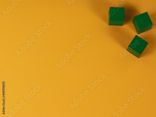 wooden cube green on yellow background