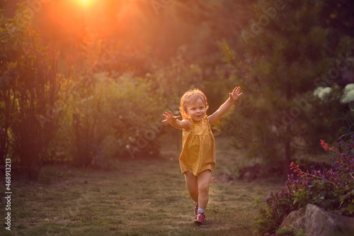 Cute little girl is running towards during the sunset. Image with selective focus and toning  © Smolina
