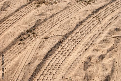 Car tyre tracks on beach sand closeup