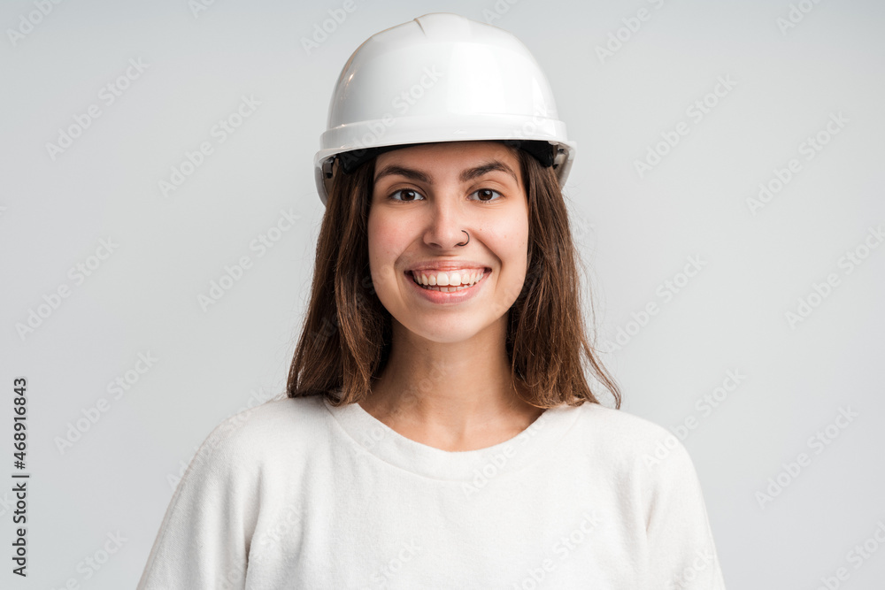 Portrait young engineer woman wearing white safety-helmet smiling toothy in shot studio isolated on white background Portrait young engineer woman wearing white safety-helmet smiling toothy in shot studio isolated on white background