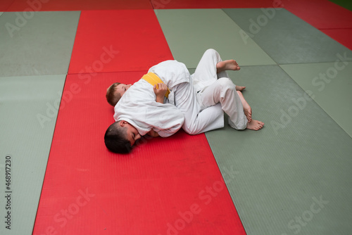 Two judo fighters showing technical skill while practicing martial arts in a fight club. The two fit men in uniform. fight, karate, training, arts, athlete, competition concept.Selective Focus