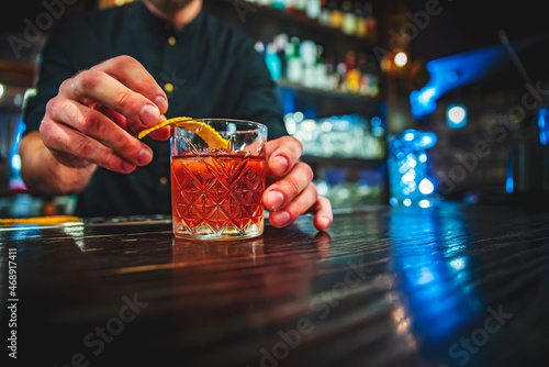 man hand bartender making negroni cocktail in bar photo