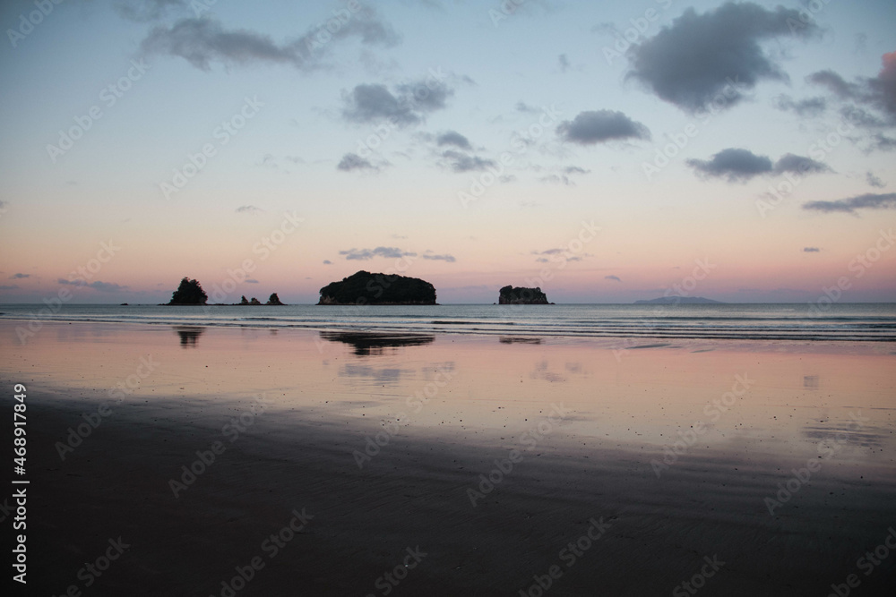 Amanecer en la playa de Nueva Zelanda con el reflejo del horizonte y las nubes en la arena Amanecer en la playa de Nueva Zelanda con el reflejo del horizonte y las nubes en la arena