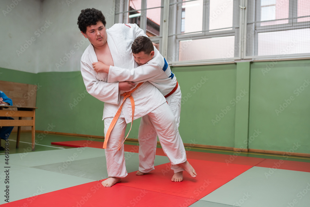 Two judo fighters showing technical skill while practicing martial arts in a fight club. The two fit men in uniform. fight, karate, training, arts, athlete, competition concept.Selective Focus