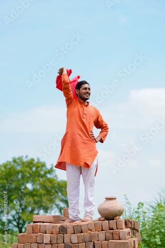 Indian farmer standing on bricks and watching on sky