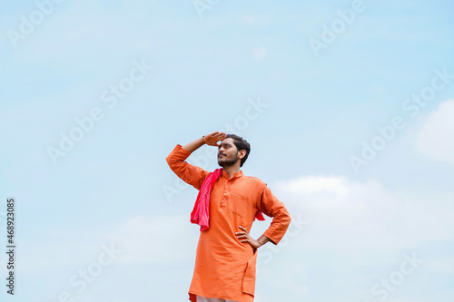 Indian farmer standing on bricks and watching on sky © PRASANNAPIX