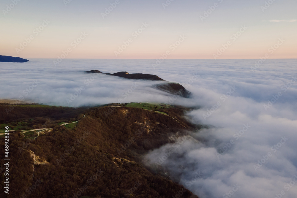 Aerial view with fog or clouds and mountains. Foggy landscape