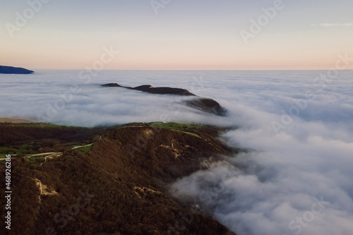 Aerial view with fog or clouds and mountains. Foggy landscape