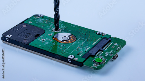 the hard drive from the computer is drilled with a large drill, macro photo