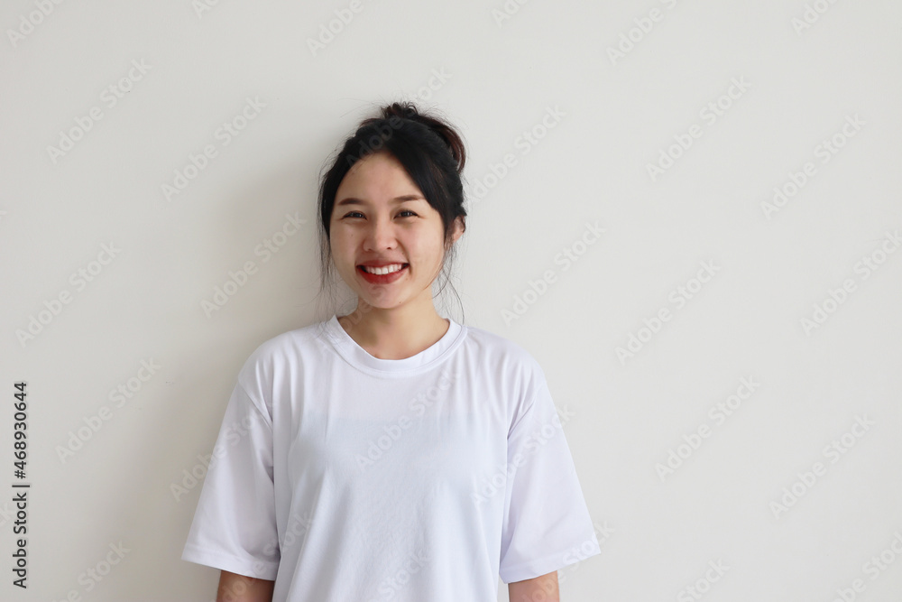 Asian young woman white t-shirt over isolated white wall smiling and looking happily Asian young woman white t-shirt over isolated white wall smiling and looking happily