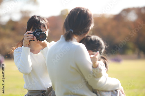 親子の写真を撮る女性カメラマン