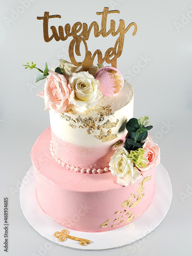 Two layered pink and white birthday cake with fresh pink and white roles photo