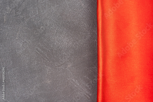 Gray concrete background with red silk or satin border, top view, background with texture and copy space for text or design