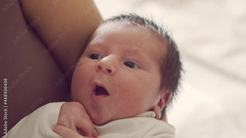Newborn baby boy and his mother at home. Close-up portrait of the infant who has recently been born. Window light. Newborn baby boy and his mother at home. Close-up portrait of the infant who has recently been born. Window light.