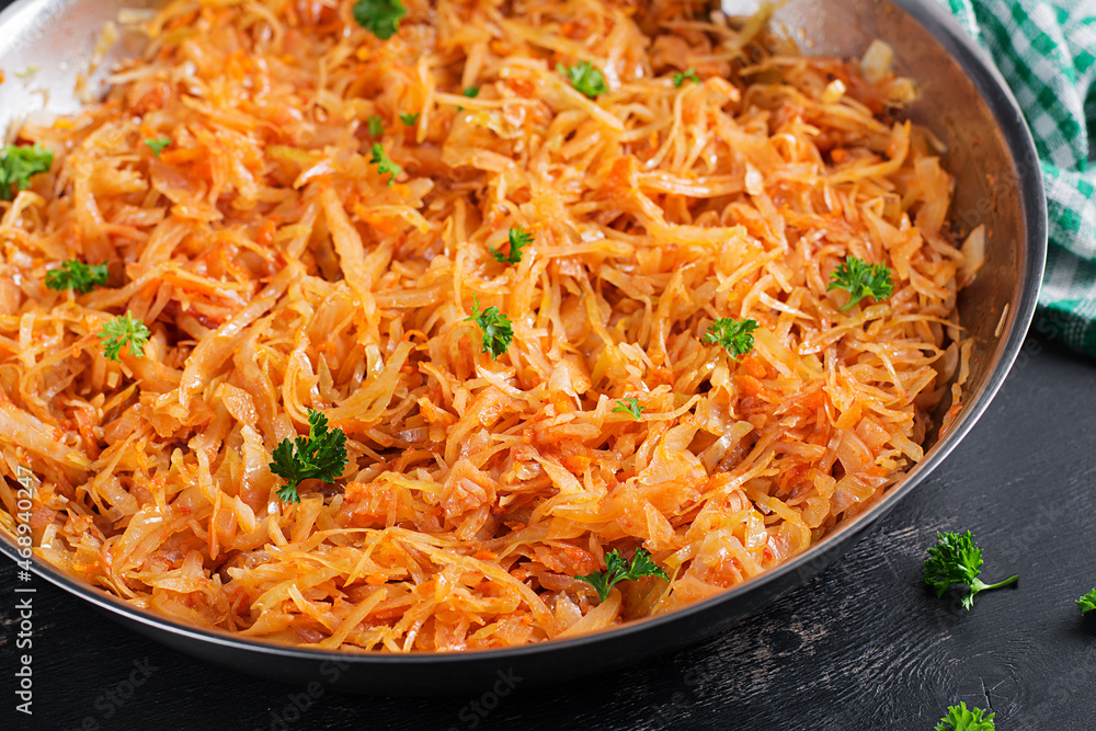 Stewed cabbage on the dark background in rustic style. Stewed cabbage on the dark background in rustic style.