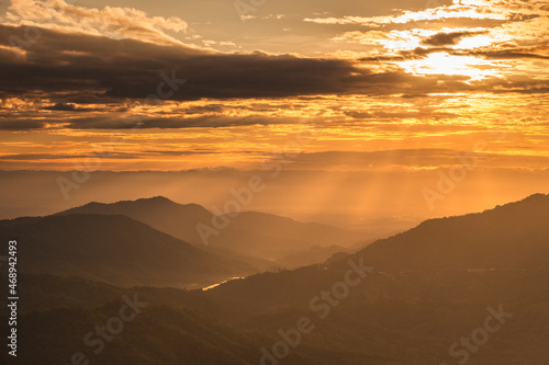 Beautiful mountain landscape at sunrise sky with clouds in sunlight. © stpadcharin