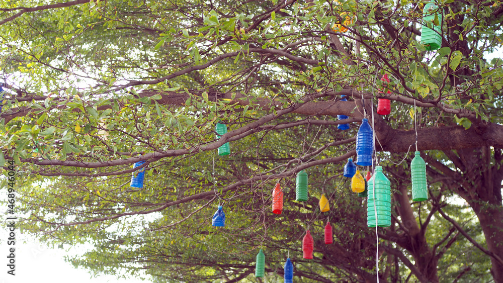 Lanterns made of colorful recycled plastic bottles hang beautifully on the tree.