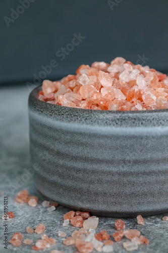 Pink himalayan rock coarse salt in a gray boel on gray background photo