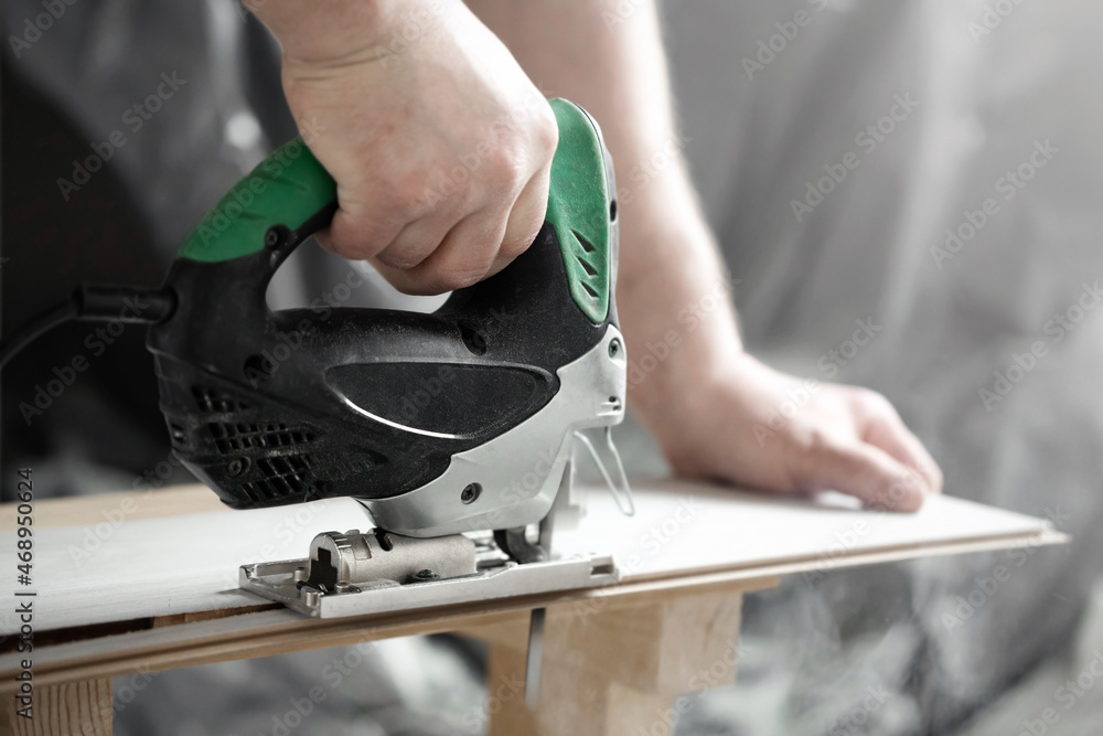 Man cutting laminate board with jig saw