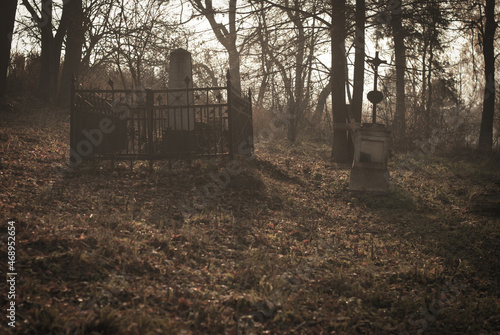 Melancholic cemetery. Couple of old and forgotten graves in autumn.