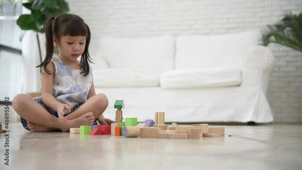 A 3 year old Asian girl is sitting, imagination and paying the wooden block toy, which is a toy that supports the development of children, to Asian girl and education concept. A 3 year old Asian girl is sitting, imagination and paying the wooden block toy, which is a toy that supports the development of children, to Asian girl and education concept.