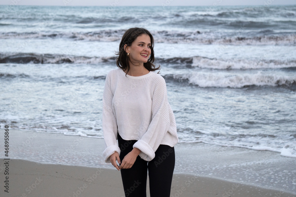 Woman smiling by the sea. Girl smiling happy. Young woman happily smiling Woman smiling by the sea. Girl smiling happy. Young woman happily smiling