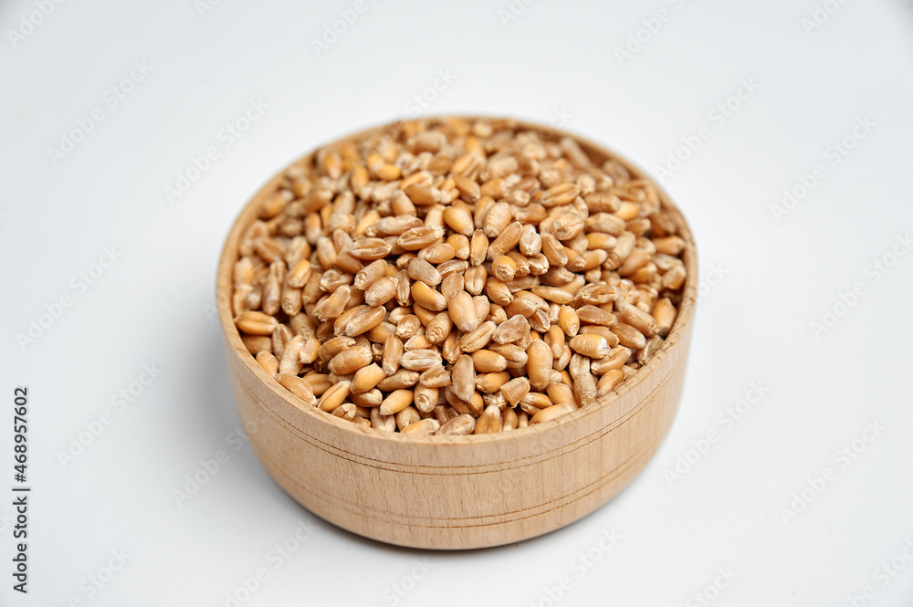 spelled grain in a wooden bowl on a white background spelled grain in a wooden bowl on a white background