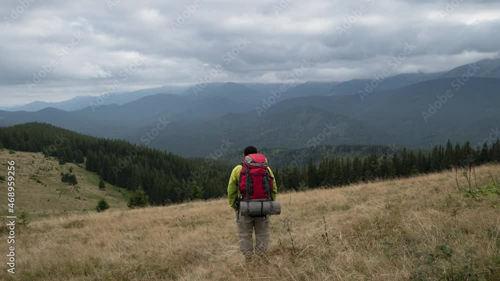 Timelapse male hiker stands on the side of a mountain and admires the nature. active recreation and hiking concept. Timelapse male hiker stands on the side of a mountain and admires the nature. active recreation and hiking concept.